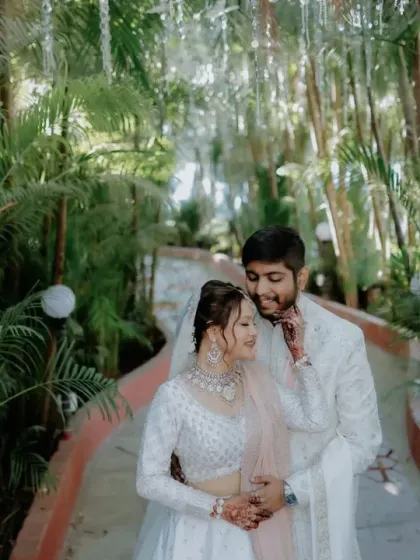 A beautiful couple shot featuring the bride in a white chikankari lehenga. A perfect rental for an elegant and coordinated wedding look.