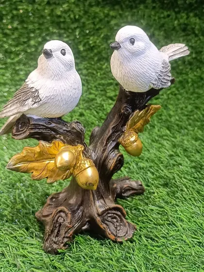 This showpiece of two white birds on a branch with golden acorns is a symbol of love and togetherness. It's a delicate and charming piece for any shelf.