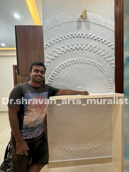 This is the most creative work I feel I've created so far! I'm pictured here with the finished abstract relief mural, which features complex, layered geometric patterns carved into the surface.