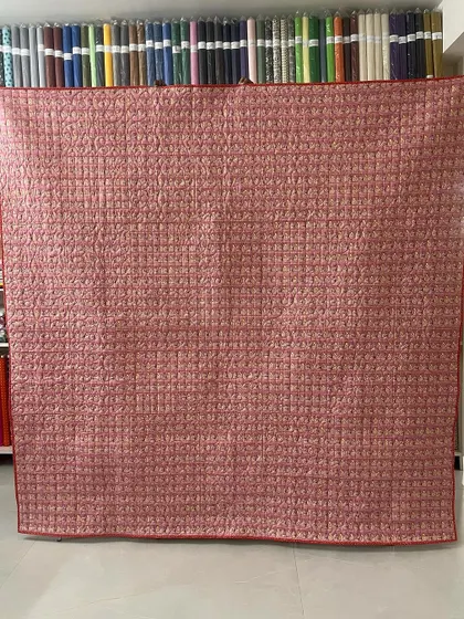 The back of the quilt, revealing the detailed quilting work across the entire surface.