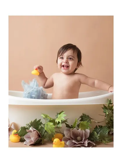 This little one is having fun playing with a rubber ducky during the bath time milestone shoot.