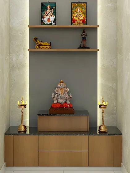 A simple and modern pooja unit set in a marble-lined niche. The floating shelves and cabinet provide a clean and uncluttered space for idols and prayer essentials.