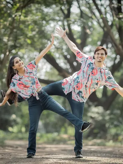 A perfectly synchronized, playful pose in a park. This kind of fun and quirky shot is a great way to showcase your personalities.