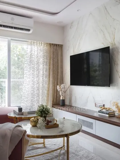 This view of 'The Adobe' living room shows the stunning effect of the book-matched marble on the TV wall, which serves as a dramatic and luxurious backdrop for the entire space.