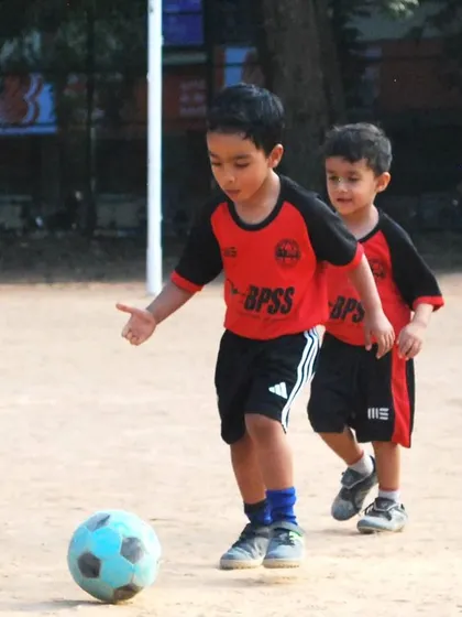 Two young players from my toddler program focused on dribbling the ball. My goal is to make learning football skills feel like a fun game.