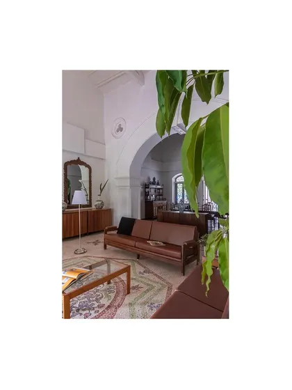 A quiet seating area where restored wooden furniture and a classic archway frame the space. We focused on creating intimate nooks within the larger, open-plan layout for personal moments.