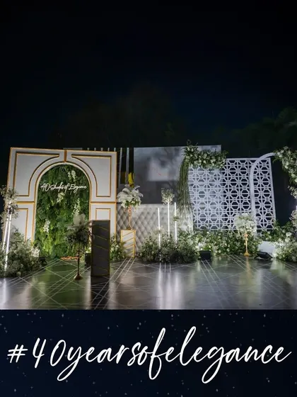 This elegant stage and photobooth, created for a '40 Years of Elegance' celebration, combined a lush vertical garden with modern architectural panels and a custom neon sign. It provided a sophisticated backdrop for photos.