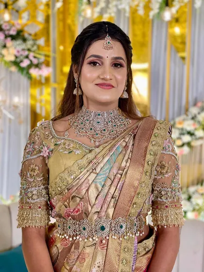 A close-up of the bride's serene expression. The delicate embroidery on her blouse and her stunning jewelry complete her breathtaking look.