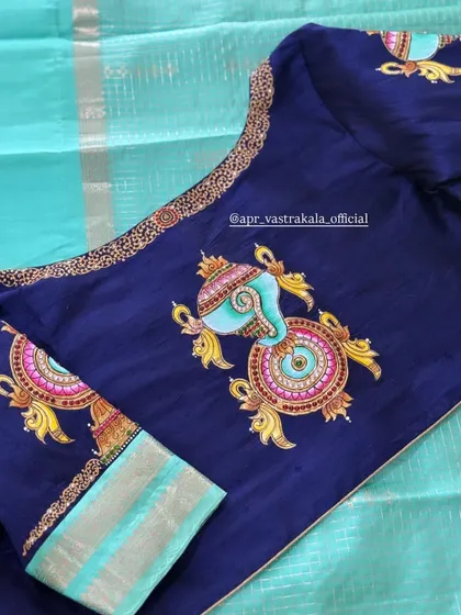 The full back view of the navy blue blouse with the painted motifs.