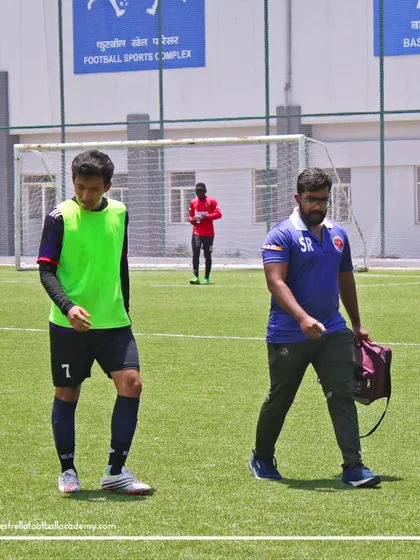 Our on-duty physio walking with a player. Player health and safety are our top priorities, especially during high-stakes trials. We ensure professional medical support is always available.