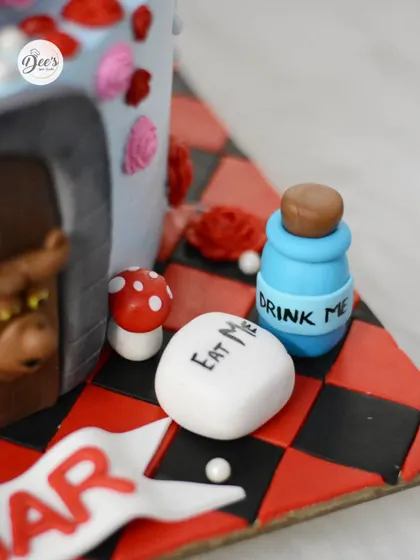 The famous 'Eat Me' and 'Drink Me' treats, recreated in fondant, add to the whimsical theme.