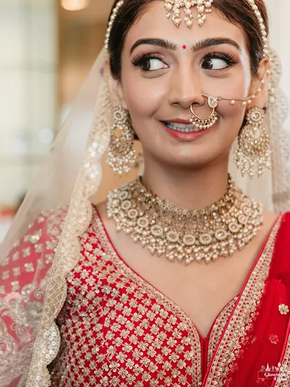 A close-up portrait of the bride, Shivani, with a playful and happy expression, showcasing her beautiful makeup and nath.