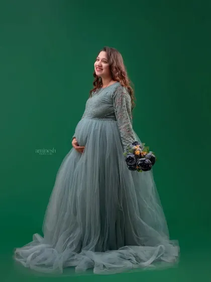 This dusty blue gown with detailed lacework on the sleeves offers a soft and romantic look. The solid green background makes the color of the dress pop, creating a beautiful contrast.