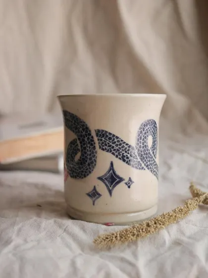 The 'Slithering Time' mug. I used the sgraffito technique on this piece, carving through a layer of color to reveal the clay body underneath. It creates such a beautiful, illustrative effect.