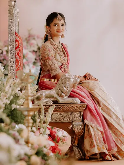 This young client looks like a princess in her custom-designed half saree. The pink and gold ensemble with a heavily embroidered blouse is perfect for her half saree function.