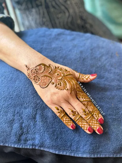 A delicate Arabic-style henna design on the back of the hand.