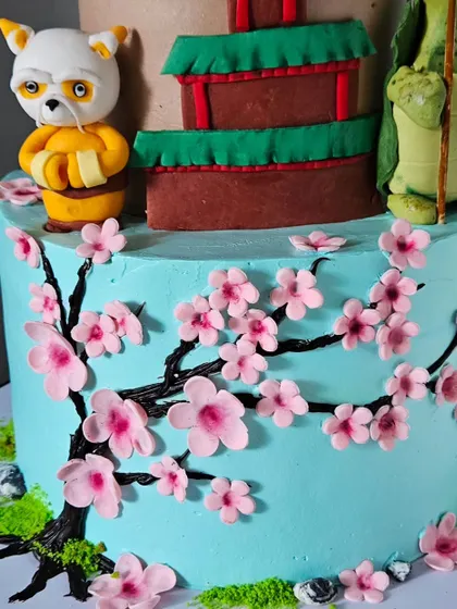A detail shot of the hand-painted cherry blossom branches on the Kung Fu Panda cake. This element adds a beautiful, artistic touch to the character-themed design.