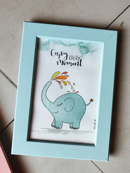 This framed artwork of a happy little elephant is a reminder to 'Enjoy Every Moment'. The simple illustration and positive message make it a perfect gift.
