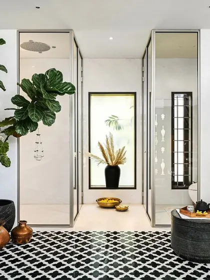 The spa includes a spacious walk-in shower with glass doors, maintaining the open and airy feel of the room. The mix of traditional Indian copper pots and modern fixtures creates a beautiful fusion of styles.