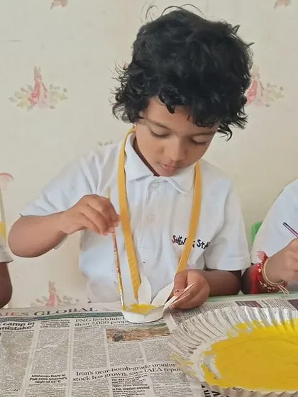 Little hands get creative with paint and spoons, making beautiful yellow flower crafts to celebrate Yellow Day.