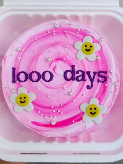 Celebrating 1000 days with this cheerful pink bento cake, decorated with smiley-face flowers.