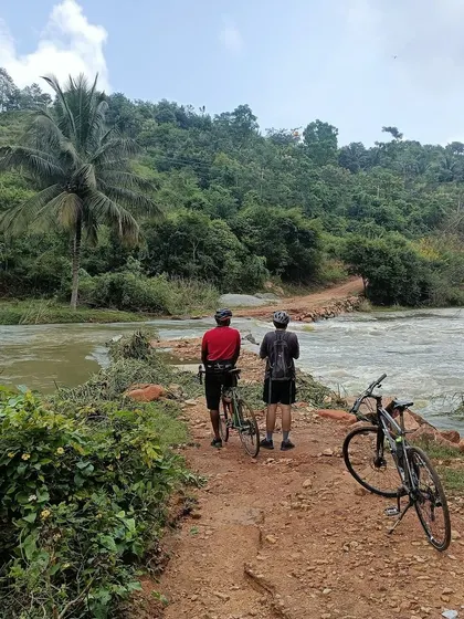 Two riders pause at a causeway with the river flowing over it. Our 'Reservoir Dogs' tour is full of adventurous and scenic moments like this.