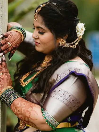 A close up shot of Shanvi, showing the intricate details of her custom blouse and her beautiful henna.
