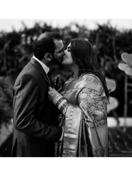A classic, romantic kiss captured in timeless black and white. This post-wedding shot focuses purely on the emotion and connection between the couple.