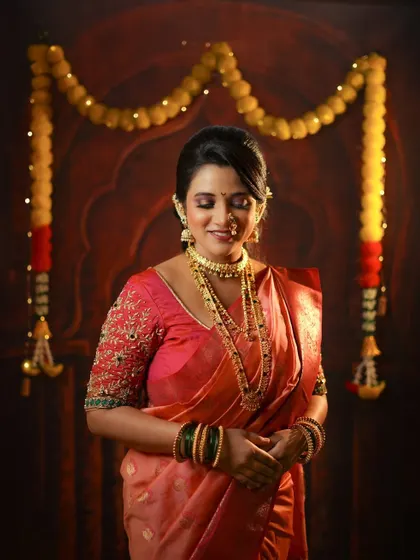 A serene portrait of a woman in her festive Diwali attire, standing gracefully in front of a traditionally decorated door.