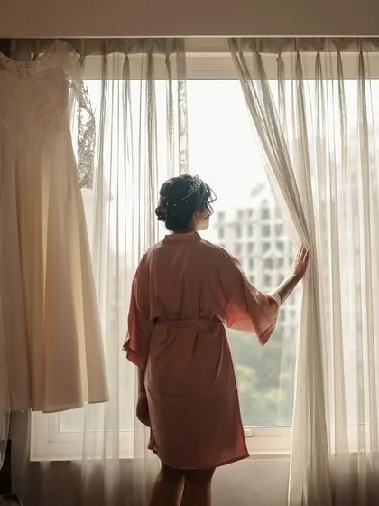 The bride looking out the window, a classic getting-ready shot full of hope and excitement.