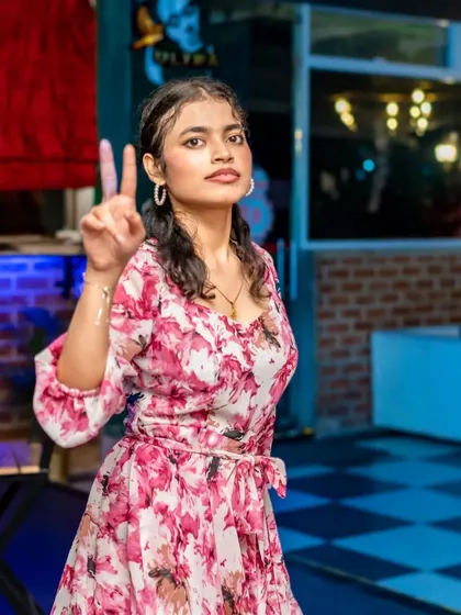 A guest flashing a peace sign, full of confidence and party spirit. The checkered floor adds a touch of retro fun.