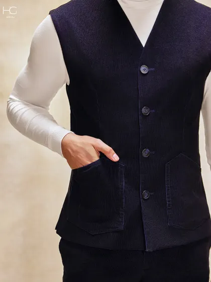 A close-up on the tailored corduroy vest, showing the rich texture of the fabric and the clean lines of its construction. It’s a versatile piece for sophisticated layering.