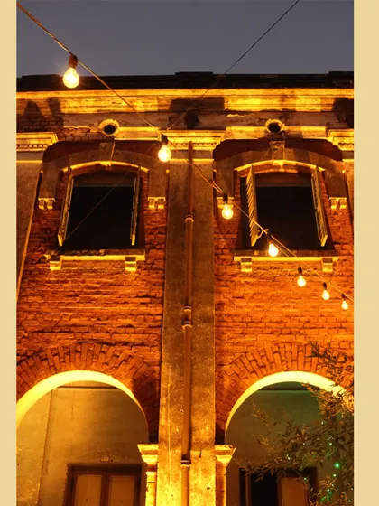 The facade of a heritage building in Chandernagore, illuminated for an evening event. Lighting is a simple yet effective tool in placemaking, highlighting architectural details and creating a warm, inviting ambiance.
