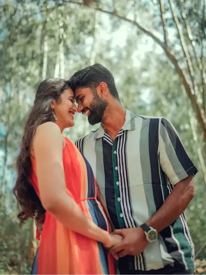 A joyful, candid moment of laughter between a couple in a forest. We believe the best pre-wedding photos are the ones that capture your true happiness.