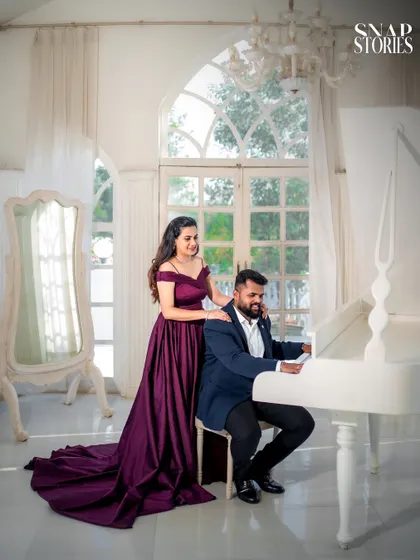 A romantic moment by a white grand piano, set against a sunlit window. This setup is perfect for couples looking for an elegant and classic pre-wedding theme.