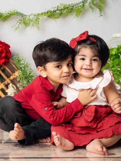 The bond between siblings is so special. We focus on creating a comfortable space where their natural affection shines through, capturing sweet moments of connection like this gentle hug between a big brother and his baby sister.