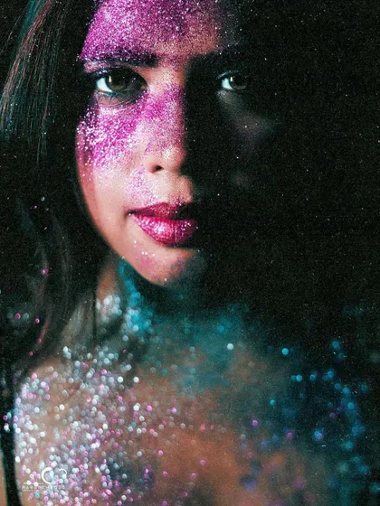 A dramatic portrait with half her face in shadow. The glitter catches the light, creating a beautiful contrast between light and dark.