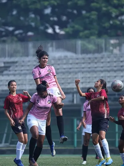 A player airborne, challenging for a header against an opponent.