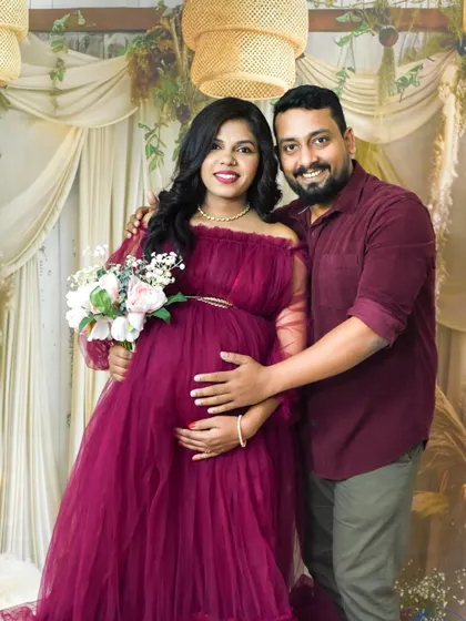 A happy couple portrait in our cozy boho studio. They are both smiling at the camera, radiating joy and excitement.