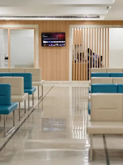 This waiting area uses a combination of teal and beige seating to add a touch of color and warmth. The layout is standardized to simplify navigation for patients and optimize staff operations.