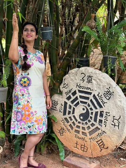 A guest poses next to a stone carving of the elements, a symbol of our connection to the natural world.