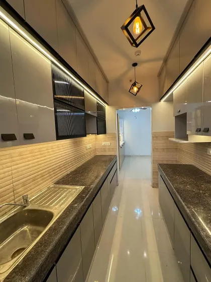 A view down a long parallel kitchen. I used high-gloss grey laminate for the cabinets and textured tiles for the backsplash, with profile lighting running along both sides for excellent illumination.