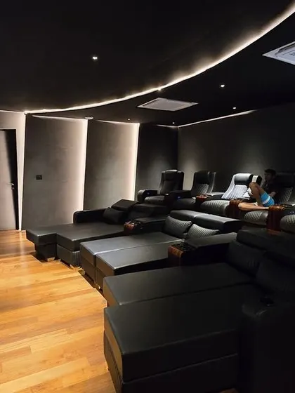 A super-luxury home cinema in Nellore, Andhra Pradesh, with a unique, curved seating arrangement that includes custom-built loungers and recliners.