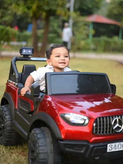 A joyful, candid shot of the boy laughing while playing in his toy car during our outdoor session.