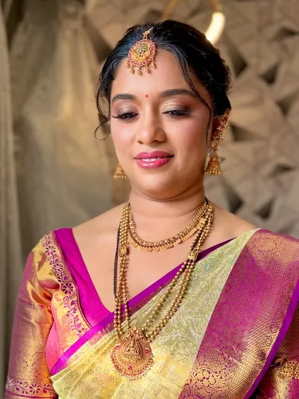 Eyes closed to showcase the delicate gold shimmer on the eyelids, a classic choice for South Indian brides.