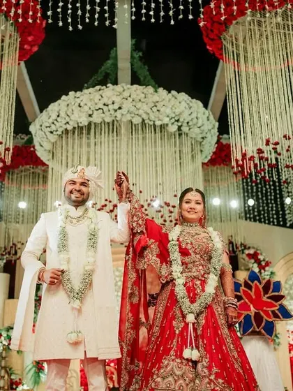 The final pose, a picture of happiness. After the grand varmala, the couple smiles, surrounded by stunning decor and the love of their families.