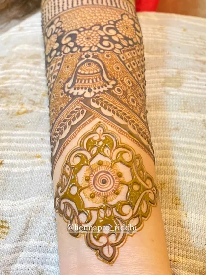 Mastering the finishing touches. This close-up shows a beautifully executed floral patch, highlighting the clean lines and consistent application of the henna paste.