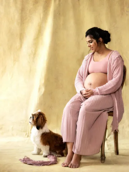 Just the two of them, waiting for the little one. This studio maternity portrait with their dog is a beautiful testament to their complete family.