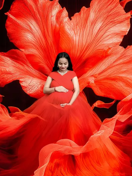 This is one of my favorite setups in the studio. The vibrant red gown and the oversized flower backdrop create a powerful and artistic portrait that truly celebrates the strength of motherhood.
