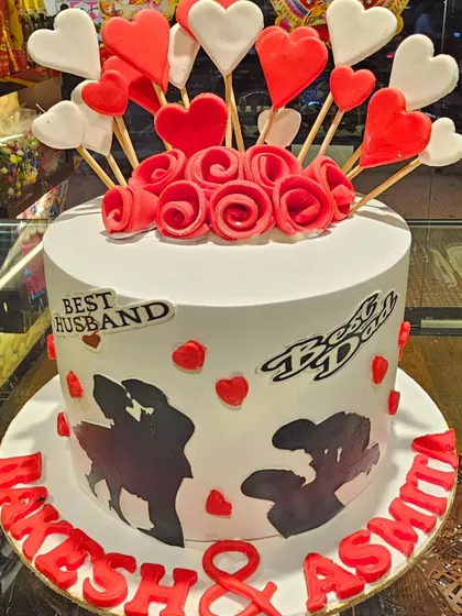 A heartfelt cake celebrating the 'Best Husband' and 'Best Dad'. This design is decorated with romantic couple silhouettes and a burst of red and white hearts.